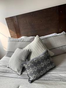 a bed with pillows and a wooden head board at Apartamento de lujo, MODERNO estilo NEW YORK in Guatemala