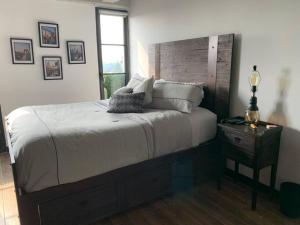 a bedroom with a large bed with a wooden headboard at Apartamento de lujo, MODERNO estilo NEW YORK in Guatemala