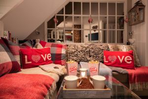 a living room with a couch with red pillows and popcorn at The Nest Barnlette in Wrenbury