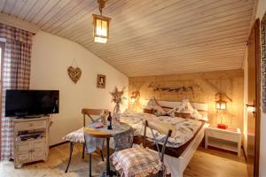 Schlafzimmer mit einem Bett, einem TV und einem Tisch in der Unterkunft Gästehaus Barbara Schwaiger in Inzell