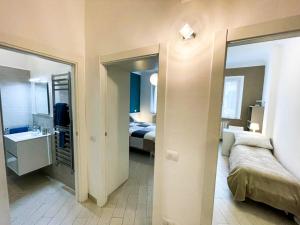 a bedroom with a bed and a bathroom with a mirror at FirstHouse - nel centro storico con Parcheggio Gratuito in Siena