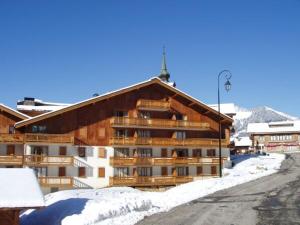 a large apartment building with snow on the ground at Duplex 4 chambres avec piscine et parking au centre du village - 10 pers - FR-1-505-122 in Notre-Dame-de-Bellecombe
