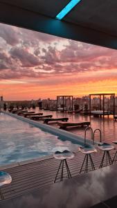 a pool on the roof of a building with a sunset at Los Silos Hotel in Santa Fe