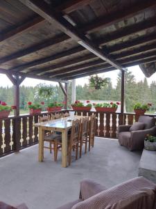 a patio with a table and chairs on a deck at Casa din Deal-Apuseni in Ocoale