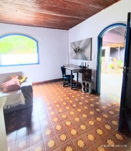 1 dormitorio con cama, escritorio y mesa en Hospedaria e Camping Quintal do Mundo, en Lumiar