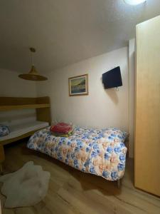 Habitación pequeña con cama y escritorio. en Casa Maria, en Pieve Tesino