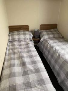 two beds sitting next to each other in a room at A family-friendly, eight birth, 2019 Abbey Trieste Caravan in Morecambe