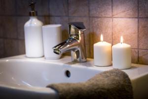 a bathroom sink with three candles and a faucet at Como Unique View - byMyHomeinComo in Como