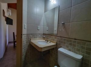 a bathroom with a sink and a toilet and a mirror at Alojamientos Estrellas Azules in Colón