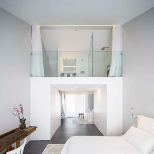 a bedroom with white walls and a bed and a mirror at Sublime Comporta Country Retreat & SPA in Comporta