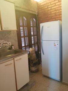 uma cozinha com um frigorífico branco e um lavatório em DEPARTAMENTO Alicia 2 em Santiago del Estero