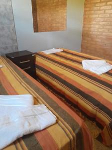 dos camas sentadas una al lado de la otra en una habitación en DEPARTAMENTO Alicia 2 en Santiago del Estero