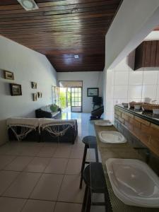 uma casa de banho com três lavatórios num quarto em Casa na Ilha da Crôa em Barra de Santo Antônio