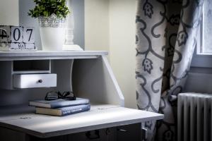 a shelf with books and a pair of glasses on a table at Como Unique View - byMyHomeinComo in Como