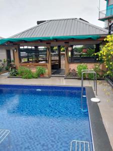 a pool in front of a building with a gazebo at Bidesi Apartments in Suva