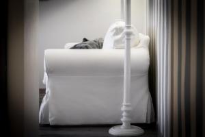 a cat laying on top of a white bed at Como Unique View - byMyHomeinComo in Como