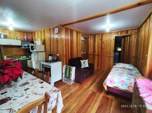 Habitación con cama y cocina con mesa en Cabana, lagoas e natureza!, en Relvado