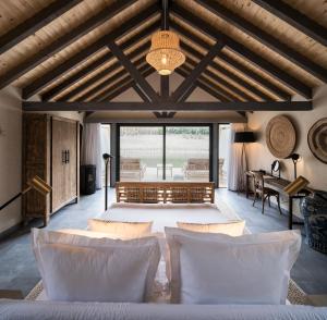 a living room with white furniture and a ceiling with beams at Sublime Comporta Country Retreat & SPA in Comporta