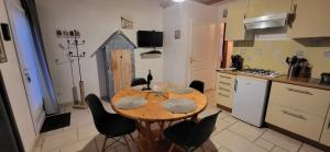 Una cocina con una mesa de madera y sillas negras. en Maisonette de pays classée 3 étoiles, en La Cotinière 5 fotos más