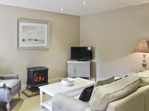 a living room with a couch and a fire place at The Dovecote in Romaldkirk