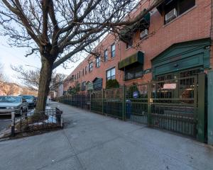 a building with a fence and a tree on a street at Travel Nurse Housing & Internationals Travelers, College Student, Young Business Professionals - Corporate Housing Accommodation, Offsite Employee & Vacation Temporary Short-Terms Bookings in Brooklyn