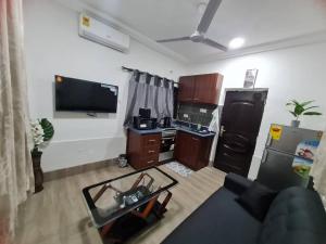 a living room with a couch and a flat screen tv at NESTA BARRON -Home Away from Home in North Legon