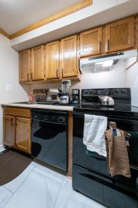 a kitchen with black appliances and wooden cabinets at Travel Nurse Housing & Internationals Travelers, College Student, Young Business Professionals - Corporate Housing Accommodation, Offsite Employee & Vacation Temporary Short-Terms Bookings in Brooklyn