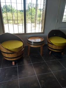 dwa krzesła i stół w pokoju z oknem w obiekcie Casa en Amaicha w mieście Amaicha del Valle