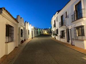 an empty street in a town with white buildings at Stylish 3 bed house 2 bathrooms with patio, roof terrace and communal pool 5 minutes away from the beautiful Spanish white village of Casares Pueblo and only 20 mins from the sea in Casares