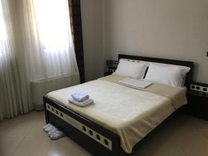 a bedroom with a large bed with two towels on it at Hotel Camping Lin in Pogradec