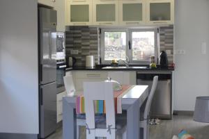 a kitchen with a table and chairs and a refrigerator at Pedras Negras House in Biscoitos