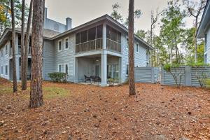 a large house with a porch and trees at Myrtle Beach Condo in Tidewater with Pool and Golf! in North Myrtle Beach