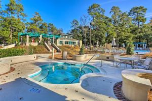 a pool with a patio and a table and chairs at Myrtle Beach Condo in Tidewater with Pool and Golf! in North Myrtle Beach