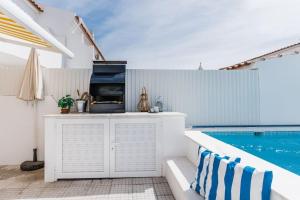 a outdoor kitchen with a grill next to a swimming pool at StaySalty - Resort Style Family Beach House with Pool in Altura