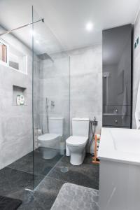 uma casa de banho com um WC e uma cabina de duche em vidro. em Rose House By Atlantic Holiday em Machico