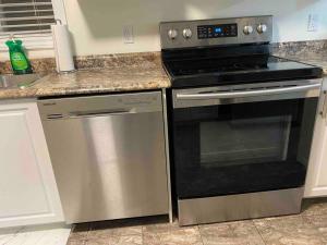 a kitchen with a stove and a dishwasher at Executive Apartment at Southend Sudbury in Sudbury