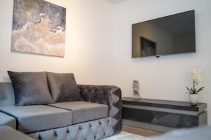 a living room with a couch and a flat screen tv at Pavlova House - Luxury 2 Bed Apartment in Aberdeen City Centre in Aberdeen