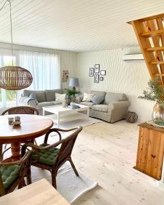 a living room with a couch and a table at Hyggeligt Sommerhus med havudsigt in Humble