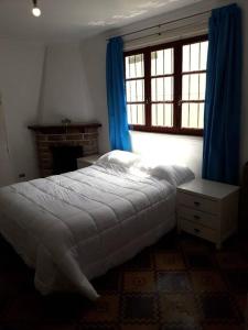 1 dormitorio con 1 cama y una ventana con cortinas azules en casa MiLú, en zona Güemes en Mar del Plata