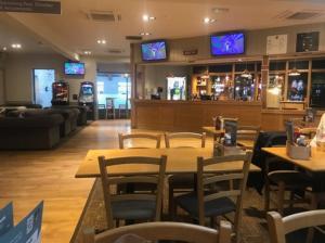 a restaurant with tables and chairs and televisions at A family-friendly, eight birth, 2019 Abbey Trieste Caravan in Morecambe