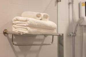 a pile of towels on a towel rack in a bathroom at AMIRI PLACE HOTEL in Chiang Mai