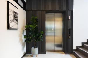 清邁的住宿－AMIRI PLACE HOTEL，走廊上设有门和盆栽