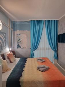 sypialnia z dużym łóżkiem z niebieskimi zasłonami w obiekcie Апартамент BLUE SUMMER - уют, близо до морето w Burgas