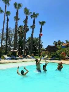 a group of people playing with a frisbee in a swimming pool at Casa Taos in Marrakech