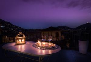 a table with candles and wine glasses on a balcony at Como Unique View - byMyHomeinComo in Como