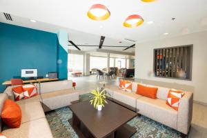 a living room with couches and a table at Avid Hotels - Denver Airport Area, an IHG Hotel in Denver