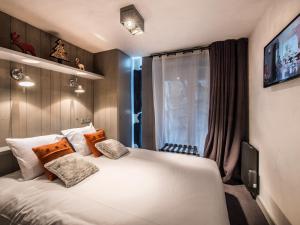 a bedroom with a large white bed with pillows at Appartement Courchevel 1650, 3 pièces, 6 personnes - FR-1-563-8 in Courchevel