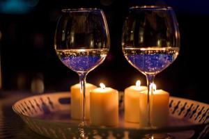 two glasses of wine and candles on a table at Como Unique View - byMyHomeinComo in Como