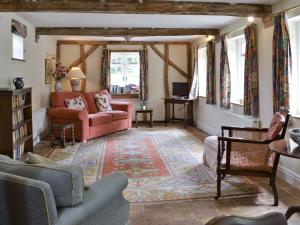 a living room with a pink couch and chairs at The Coach House in Aston Cantlow