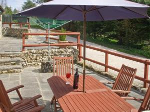 een tafel met een fles wijn en een paraplu bij Cider House in Hawkchurch
